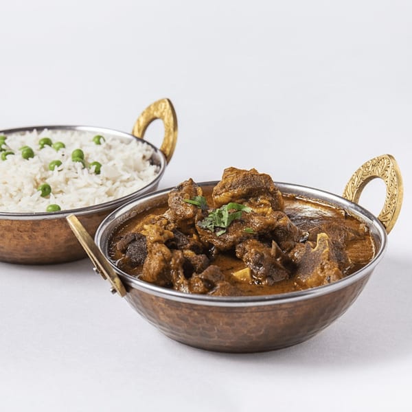 Yak and Yeti Himalayan Cuisine's goat curry with cilantro and a side of white rice with green peas.